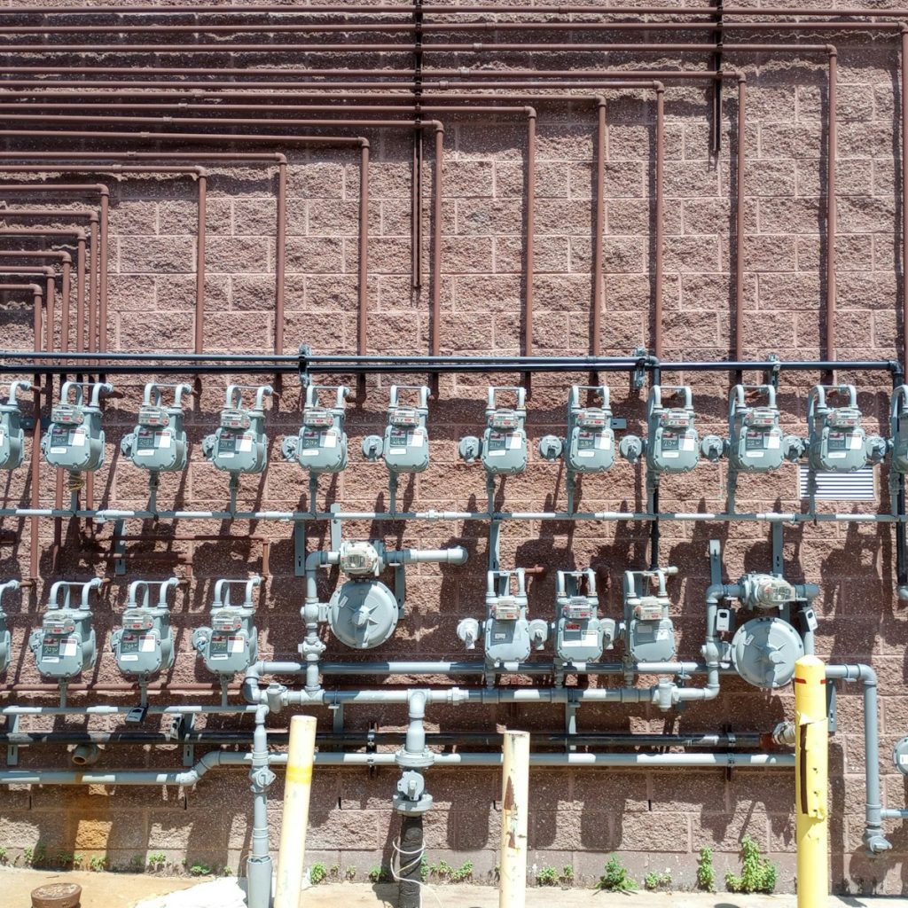 a bunch of pipes are attached to the side of a building