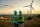 Wind turbine, engineering team and laptop on night farm for clean energy, power and electricity. Electrician or technician man and woman in nature for windmill and eco environment online maintenance